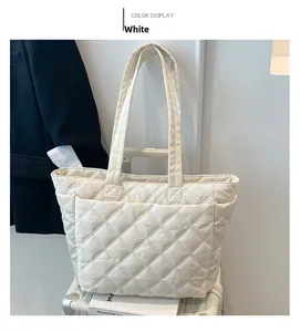 Detail of cream quilted tote bag with diamond pattern on luggage for travel