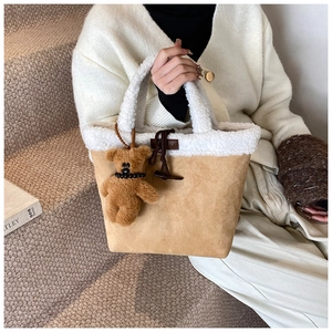 Detail of lamb wool trim and khaki suede tote bag with cute bear charm and toggle button