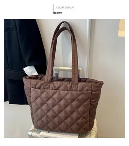 Close-up of brown quilted nylon tote bag with puffer texture and wide shoulder straps
