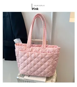 Pink quilted tote bag placed on luggage showing a travel and commuter scene setup