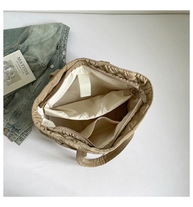 Interior detail of a quilted tote bag featuring a zipper pocket and functional compartments
