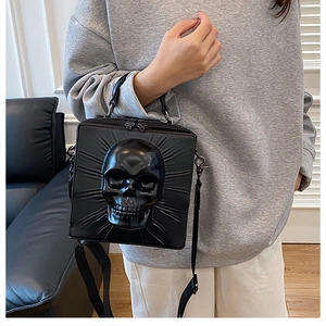 Gothic skull crossbody bag with 3D relief on black leather, worn over the shoulder