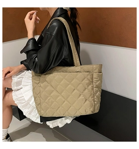 Close-up of khaki quilted tote bag with diamond stitching and wide shoulder strap detail