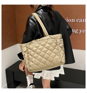 Detail of champagne quilted nylon tote bag with satin finish and wide shoulder strap