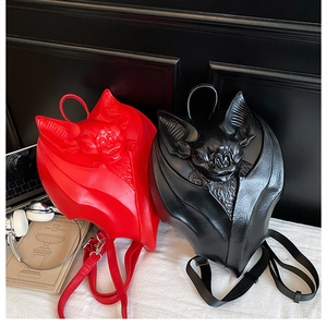Detail of bat-shaped gothic backpacks in red and black PU leather with embossed texture