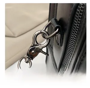 Detail of silver-tone metal swivel hook and crocodile embossed leather strap on bag