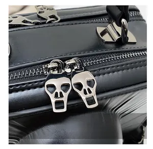 Detail showing skull-shaped silver zippers on black punk-style leather bag