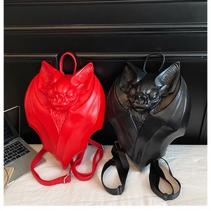 Detailed view of Gothic bat-shaped backpacks in vibrant red and matte black PU leather
