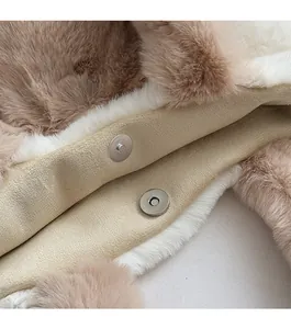 Detail of metal magnetic buckle closure on fluffy two-tone faux fur tote bag