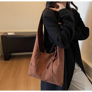 Detail der kaffeebraunen Wildleder-Hobo-Tasche mit seitlichem Kordelzug und Metallschnalle