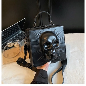 Macro view of gothic black square bag featuring a 3D skull relief and shiny PU leather texture
