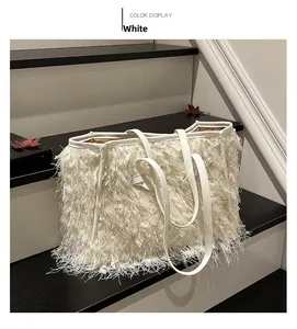 Détail du sac cabas blanc en peluche avec franges à pompons sur des marches bicolores