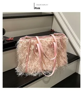 Détail d'un sac cabas rose à franges en peluche avec poignées en cuir sur un support
