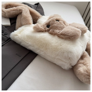 Detail of cute plush bunny tote bag with long ears and soft faux fur texture in cream