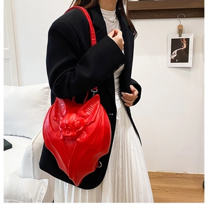 Macro shot of 3D red bat-shaped gothic crossbody bag with textured leather wing details
