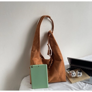 Detail of caramel suede tote bag with drawstring, showing large capacity for laptop