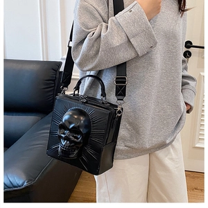Detailed close-up of a 3D skull shaped crossbody bag with wide nylon strap on a model