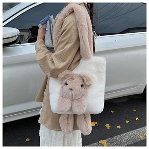 Detail of white plush tote bag featuring a pink cartoon bear doll and soft furry shoulder strap