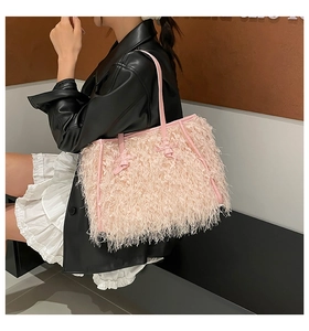 Détail du cabas en plumes rose clair avec anses en cuir sur une tenue de mannequin