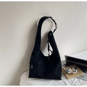 Detail view of black canvas tote bag with adjustable drawstring and metal ring accent