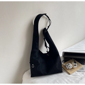 Detail of black canvas hobo bag featuring knot decor and silver metal ring buckle