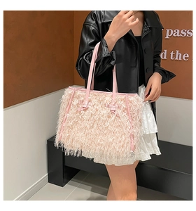Détail du sac fourre-tout rose en peluche avec nœuds en cuir et fines bretelles