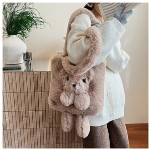 Detail of soft plush tote bag with a 3D teddy bear charm and fluffy texture