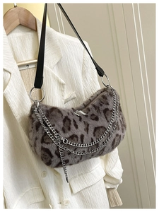 Détail du sac en peluche léopard avec doubles chaînes argentées sur blazer blanc