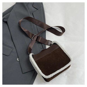 Detail of faux shearling trim and brown suede material on this crossbody square bag
