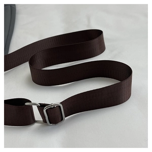 Detail of adjustable dark brown nylon strap with silver metal buckle for crossbody bags