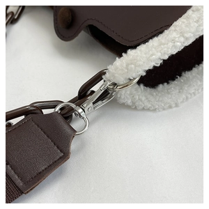 Detail of faux leather handbag showing soft fleece trim and silver chain link strap