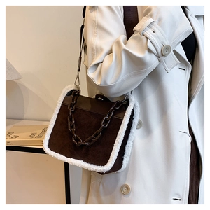 Detail of vintage brown suede bag with plush white trim and stylish acrylic chain strap