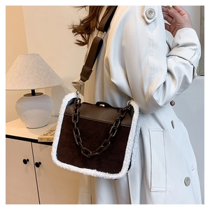 Detail of vintage brown suede handbag with white faux shearling trim and resin chain