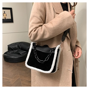Detail of crossbody bag with black suede and faux fur trim worn with a wool coat