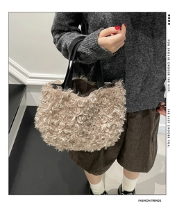 Detailed shot of beige faux shearling tote bag with black leather straps and inner lining