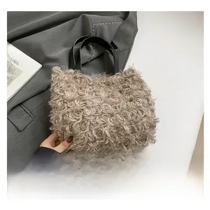 Close-up of beige faux shearling handbag with premium curly texture and black leather handles