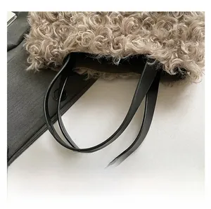 Detail shot of fluffy beige faux fur tote with a smooth black leather handle attachment