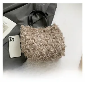 Detailed macro view of beige faux shearling tote bag with contrasting black leather handles