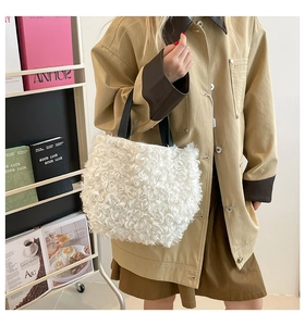 Close-up of white plush tote bag with thick faux shearling texture and black handles