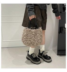 Detail shot of beige curly plush handbag with black platform leather shoes and white socks