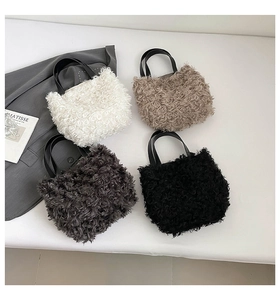 Flat lay of four plush tote bags in various colors with leather handles and art cards