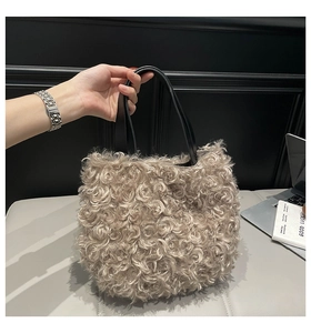 Detail of taupe faux fur handbag with black leather handle in a minimalist office setting