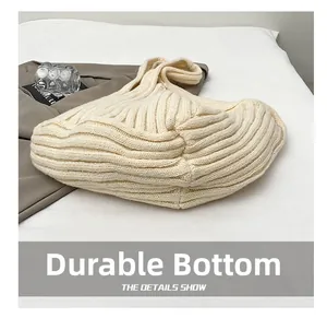 Close-up of cream knitted tote bag showing vertical ribbed texture and wear-resistant bottom