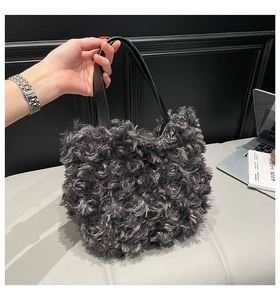 Detail of grey curly faux fur tote bag with black leather handles for winter