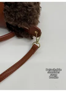 Λεπτομέρεια από χρυσό γάντζο και δερμάτινο λουράκι σε καφέ γούνινη τσάντα ώμου
