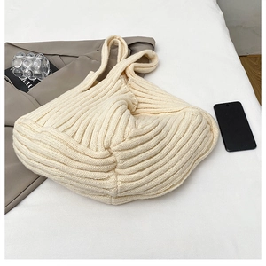 Detailed close-up of cream knit tote bag showing vertical ribbed texture and soft fabric