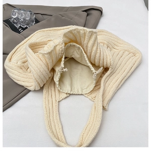 Detailed macro view of the cream knit tote bag interior with a secure drawstring liner