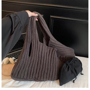Dark brown knitted tote bag with ribbed texture and black drawstring inner pouch
