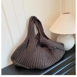Detail of coffee brown ribbed knit tote bag texture in a cozy indoor minimalist setting