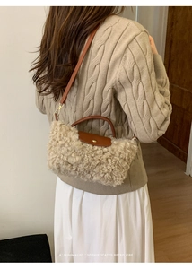 Detail showing plush lamb-like faux fur texture and brown leather flap of the handbag